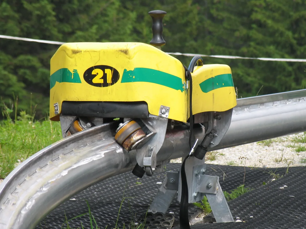 Luge individuelle et son siège fixés à un rail en montagne