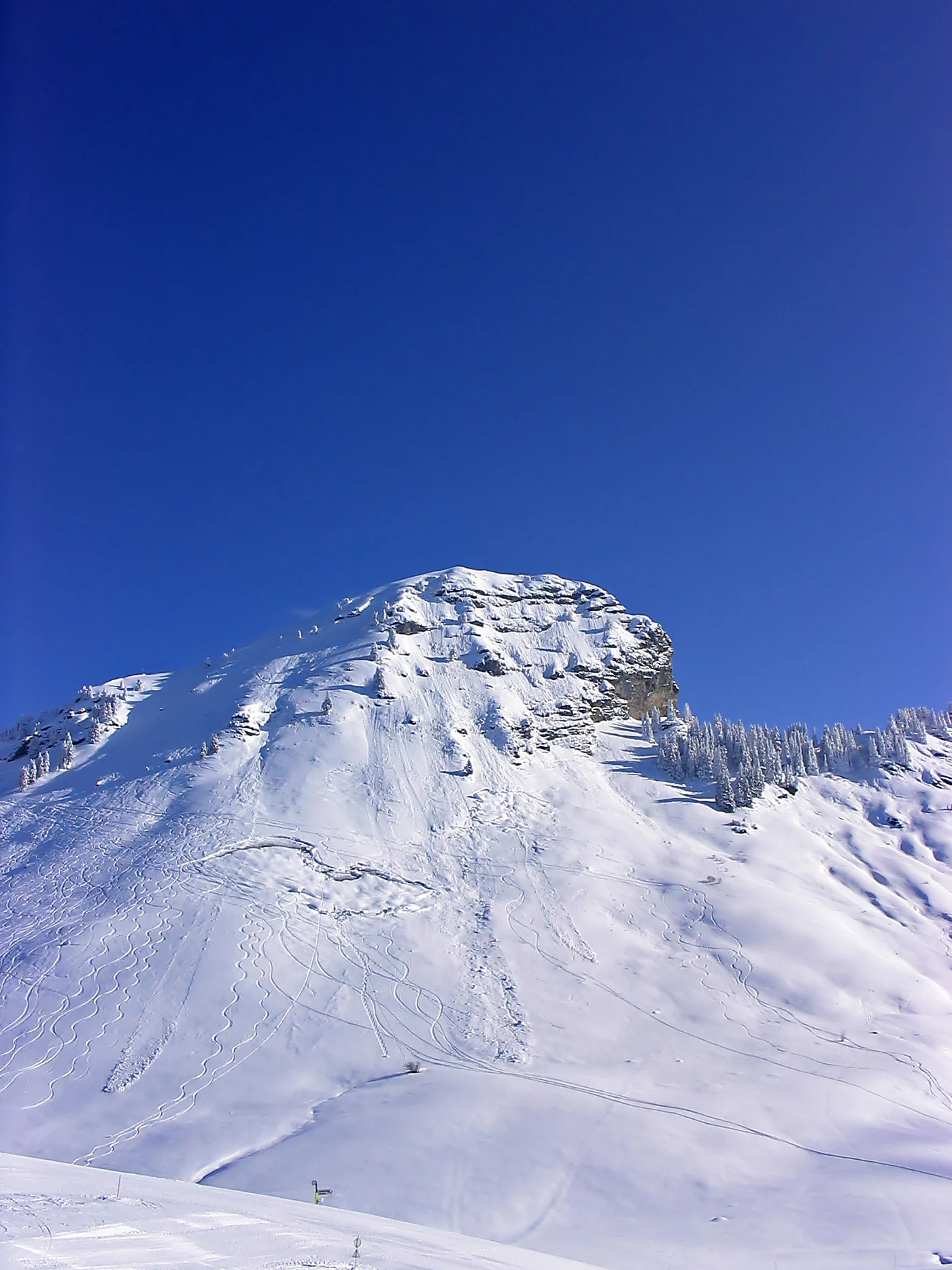 Relief rocheux et versants boisés enneigés à Morzine.