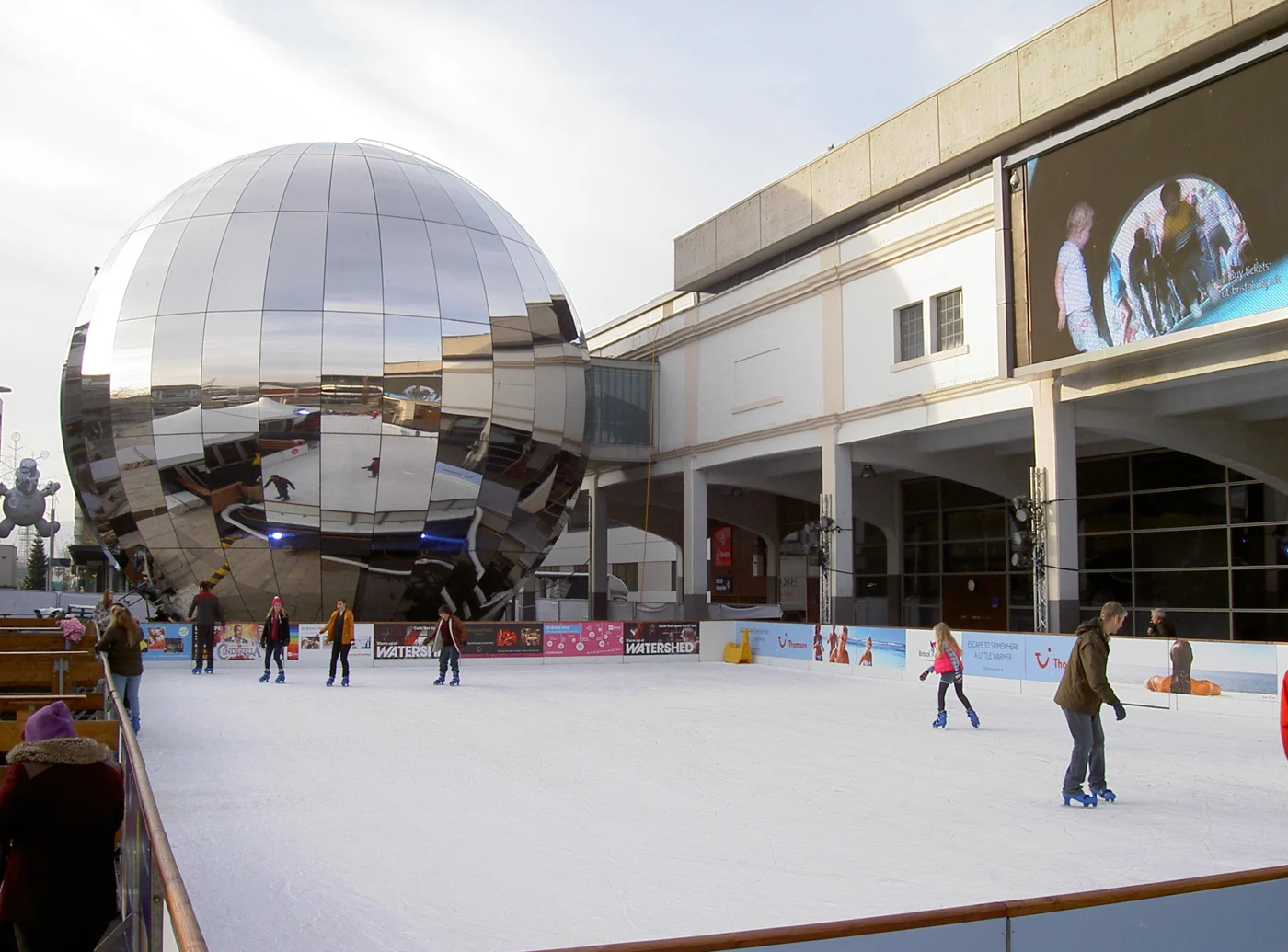 Des patineurs évoluent sur la patinoire extérieure de Millennium Square à Bristol.