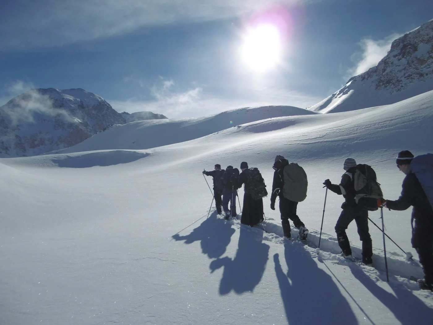 Un groupe progresse en raquettes sur une pente enneigée au Mont Thabor.