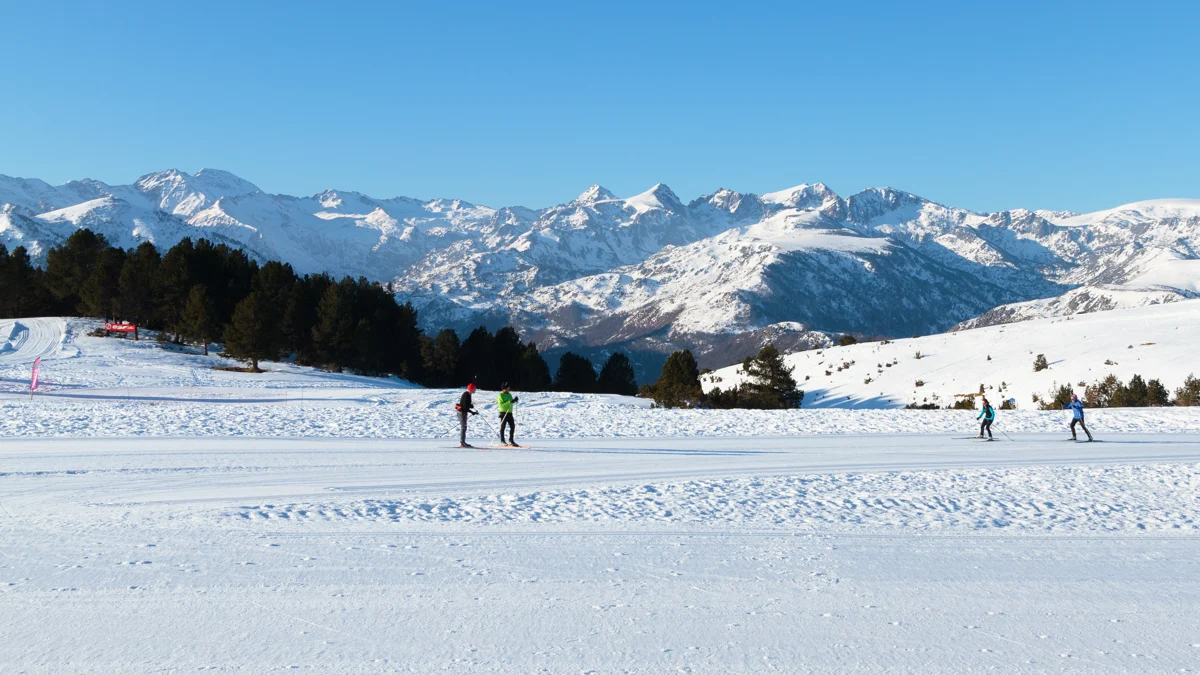 Skieurs de fond devant les sommets enneigés au plateau de Beille