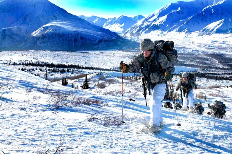 Groupe de randonneurs en raquettes à neige sur un versant enneigé de Fort Richardson, en Alaska.